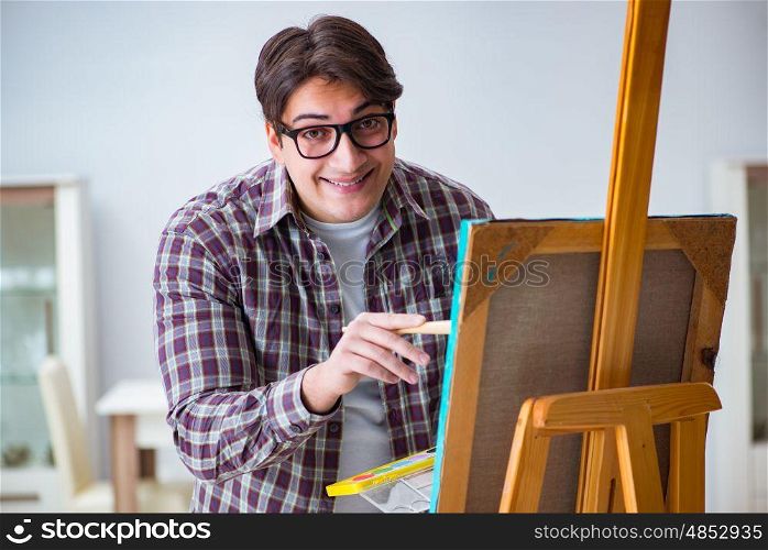 Young male artist drawing pictures in bright studio