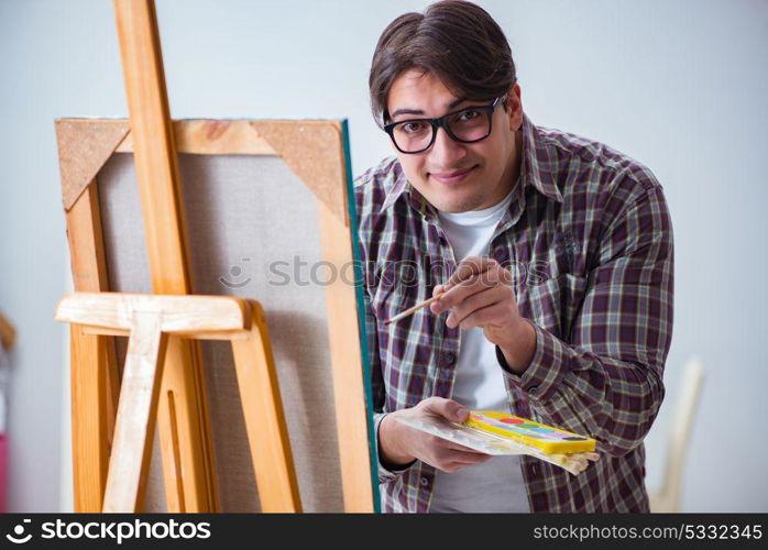 Young male artist drawing pictures in bright studio