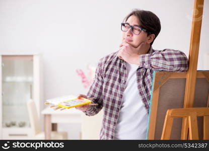 Young male artist drawing pictures in bright studio