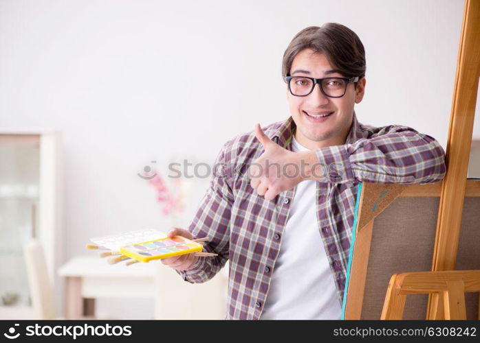 Young male artist drawing pictures in bright studio