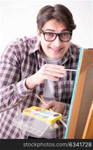 Young male artist drawing pictures in bright studio