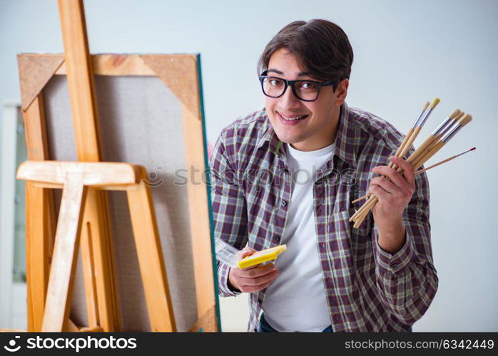 Young male artist drawing pictures in bright studio