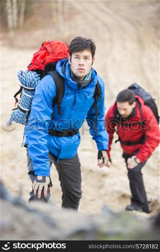 Young male backpackers hiking in forest