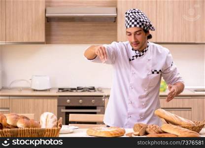 Young male baker working in kitchen 
