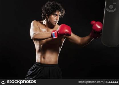 Young male boxer punching the bag