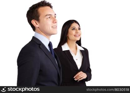 Young male business man and female business woman standing together smiling. A young business man and business woman standing together looking at a distance. They are smiling.