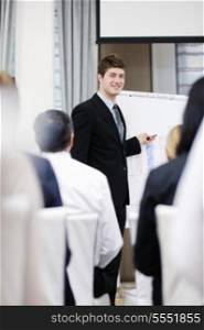 young male business man giving a presentation at a meeting seminar at modern conference room on a table board