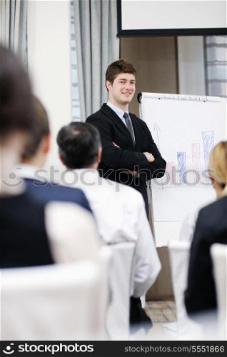 young male business man giving a presentation at a meeting seminar at modern conference room on a table board