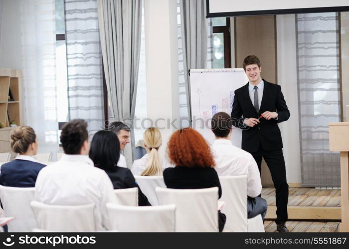 young male business man giving a presentation at a meeting seminar at modern conference room on a table board