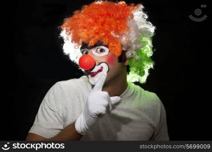 Young male clown gesturing over black background