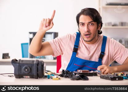 Young male contractor repairing computer  