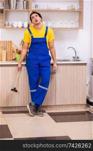 Young male contractor repairing tap at home 