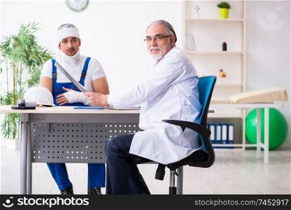 Young male contractor visiting old doctor 