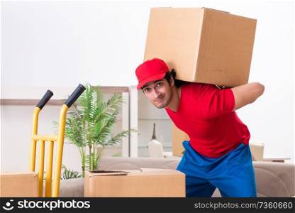 Young male contractor with boxes working indoors 