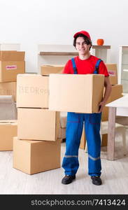 Young male contractor with boxes working indoors 