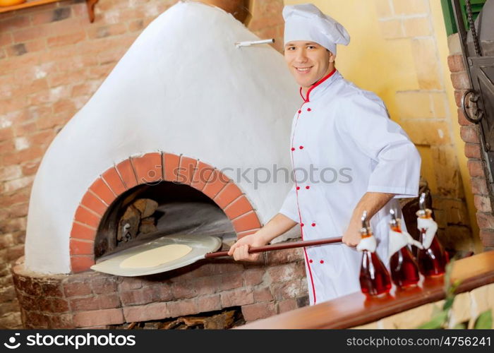 Young male cook. Image of young handsome male cook at kitchen