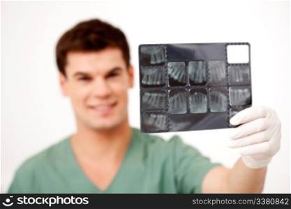 Young male dentist holding an x-ray, shallow depth of field - focus on x-ray