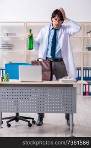 Young male doctor drinking in the office 