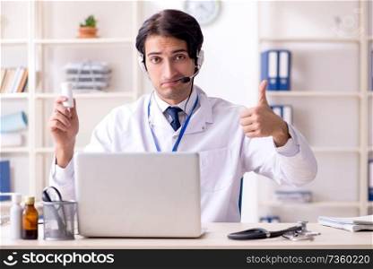 Young male doctor in telemedicine concept 
