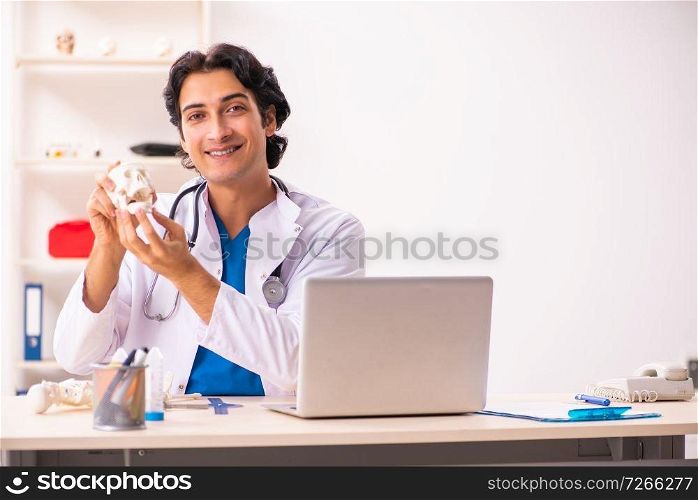 Young male doctor with human&rsquo;s skull 
