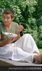 Young male eating outdoors