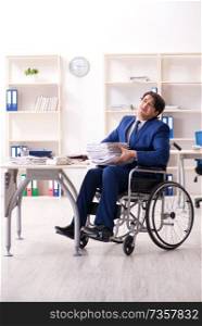 Young male employee in wheelchair working in the office 