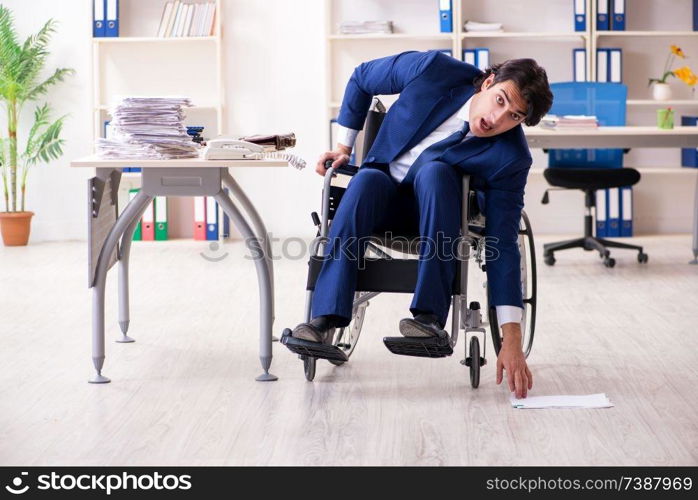 Young male employee in wheelchair working in the office 