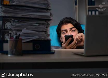 Young male employee working late at office 