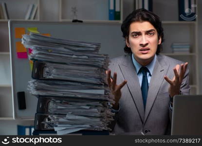 Young male employee working late at office 