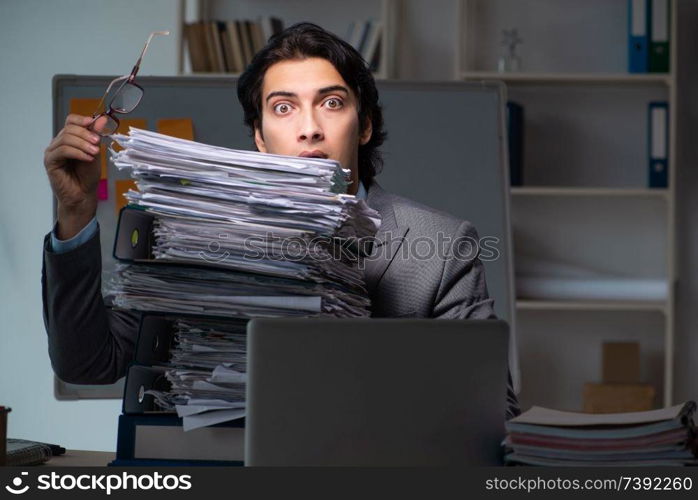 Young male employee working late at office 