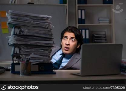 Young male employee working late at office 