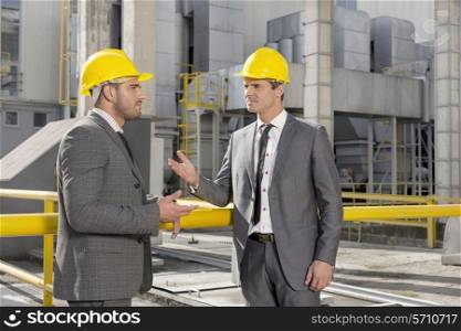 Young male engineers discussing at construction site