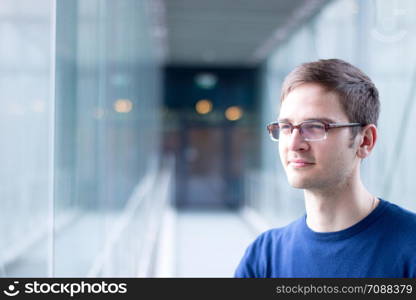 Young male entrepreneur is standing in a business building