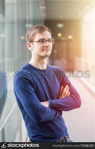 Young male entrepreneur is standing in a business building