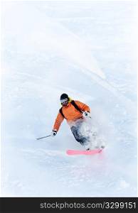 Young male freeride skier making a turn in powder snow