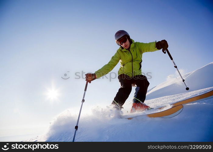 Young male freerider skier moving down in snow powder at sunset; italian alps.