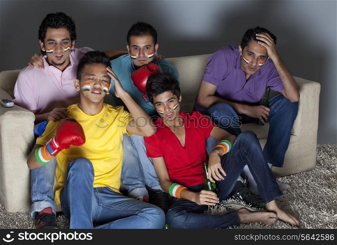 Young male friends reacting with disappointment while watching boxing match