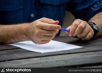 Young male hands filling out forms. Young man writing.
