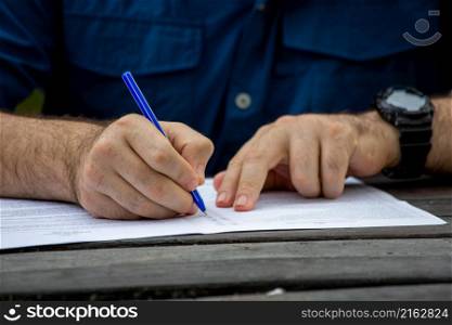 Young male hands filling out forms. Young man writing.