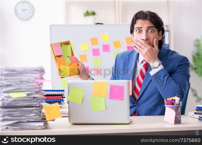 Young male handsome employee in conflicting priorities concept 