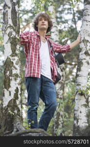 Young male hiker standing in forest