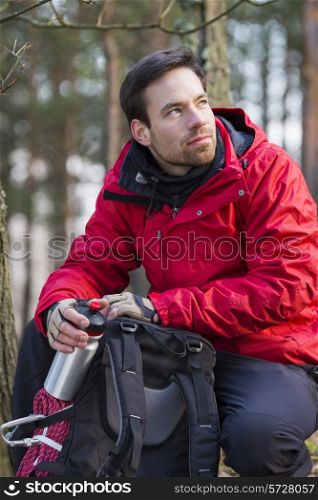 Young male hiker with backpack in forest