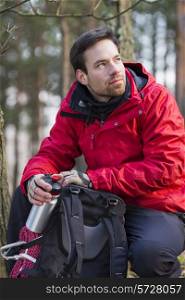 Young male hiker with backpack in forest