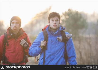 Young male hikers looking away in field