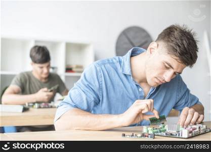 young male it technician fixing ram motherboard slot