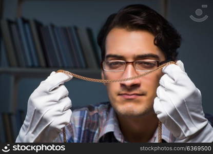 Young male jeweller working at night in his workshop