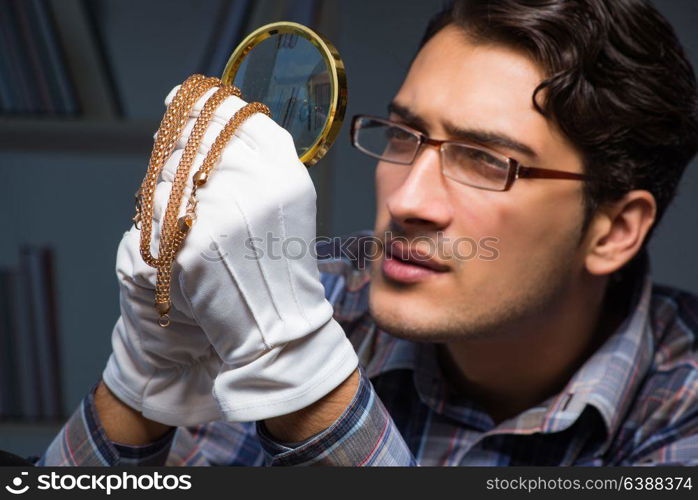 Young male jeweller working at night in his workshop