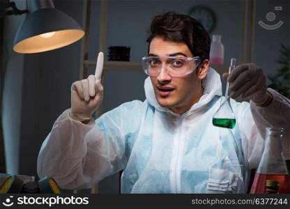 Young male lab chemist late at night in overtime time