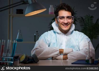 Young male lab chemist late at night in overtime time