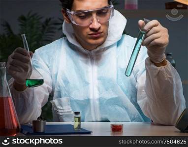 Young male lab chemist late at night in overtime time. The young male lab chemist late at night in overtime time